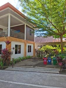 a house with a tree in front of it at Jenalfe Guest House in Camiguin
