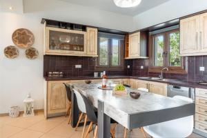 a kitchen with a large marble table and chairs at Revery Villa & House in Ios Chora +23 photos