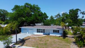 a small white house with trees in front of it at Spacious 4 bedroom 3 bath Clearwater Vacation House Cowboy Pool Fire Pit Games Close to Clearwater Beach Biking Trail Farmers Markets Harbor Health Spa Baycare Ballpark and Ruth Eckerd Hall Golf Courses in Clearwater