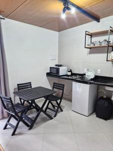 a kitchen with a table and two chairs and a counter at Loft da Árvore in Petrópolis