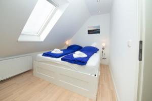 a bedroom with a bed with blue sheets and a window at Schleitraum Appartement in Rabenkirchen-Faulück +12 photos
