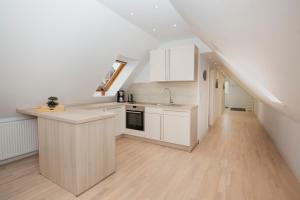 a kitchen with white cabinets and a kitchen island at Schleitraum Appartement in Rabenkirchen-Faulück