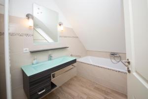 a bathroom with a sink and a mirror at Schleitraum Appartement in Rabenkirchen-Faulück