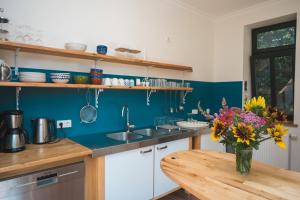 a kitchen with a vase of flowers on a wooden table at Oesenhof - Dielenwohnung in Bad Fallingbostel +17 photos