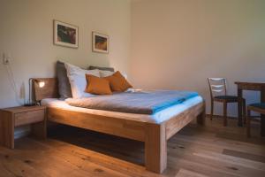 a bed in a room with a table and chairs at Oesenhof - Dielenwohnung in Bad Fallingbostel
