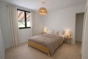 a bedroom with a large bed and a window at Les cabanes in Noaillan