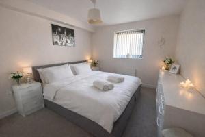 a bedroom with a large bed with two towels on it at Elegant 2-Bed 2-Bath Flat in Edinburgh in Edinburgh