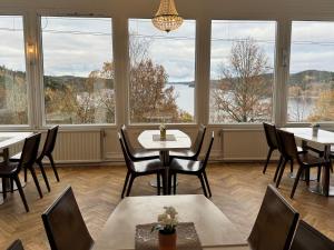 a restaurant with tables and chairs and large windows at Hotel Carl XII in Ed