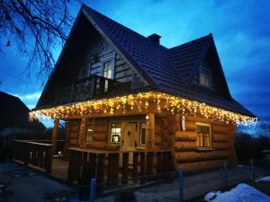 a cabin with christmas lights on it at night at Vila Vilinka & Vila Native Vilinija resort Village in Podčetrtek