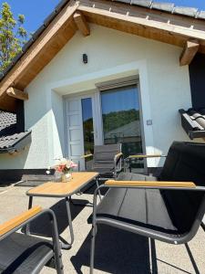a patio with tables and chairs in front of a house at Völgyzugoly Apartman in Kőszeg