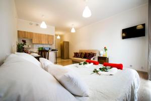 クラクフにあるApartament Polonijnaのリビングルーム付きの客室で、白いベッド2台が備わります。