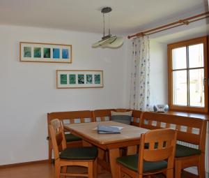 a dining room with a wooden table and chairs at Biohof Weissensteiner in Ullrichs