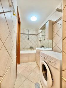 a washing machine in a bathroom with a tub at Piazza Pia Suites in Anzio