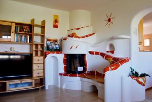 a living room with a tv and a staircase at Biohof Weissensteiner in Ullrichs