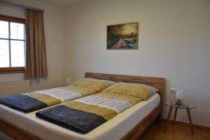 a bed in a room with two pillows on it at Biohof Weissensteiner in Ullrichs