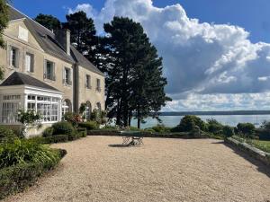 a large house with a bench in front of it at Manoir Mer & Pins in Fouesnant