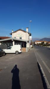 una sombra de un hombre delante de un coche blanco en Al Lago, en Adro