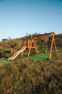 a playground with a slide in a field at Vida Pura Apartments in Odeceixe