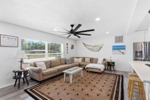 a living room with a couch and a ceiling fan at Spacious 4 bedroom 3 bath Clearwater Vacation House Cowboy Pool Fire Pit Games Close to Clearwater Beach Biking Trail Farmers Markets Harbor Health Spa Baycare Ballpark and Ruth Eckerd Hall Golf Courses in Clearwater