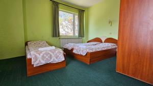 two beds in a green room with a window at Интернационал in Kulata +42 photos