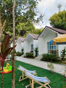 a house with two lawn chairs and a playground at Mumzai House 2 in Ko Muk