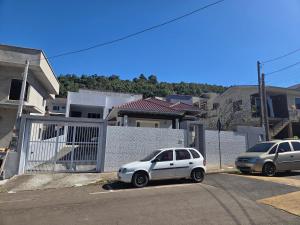 two cars parked in a parking lot in front of a house at Aconchego in Concordia