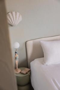 a figurine of a woman standing on a table next to a bed at Maison Le Poete in Vallauris