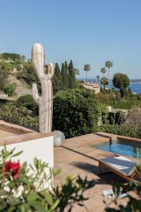 a statue of a person next to a swimming pool at Maison Le Poete in Vallauris