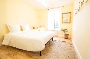 a bedroom with a large white bed and a window at Gîte cottage & spa in Joze