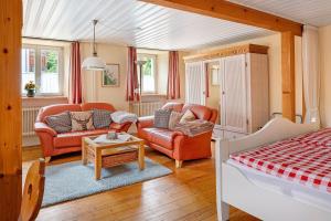 a living room with leather furniture and a bed at Haus Belchenwind in Münstertal