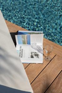 a newspaper sitting on a table next to a pool at Maison Le Poete in Vallauris +12 photos