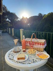 a picnic table with food and a basket of food at Recanto da Neblina in Monte Verde