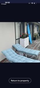 a row of blue benches in front of a building at La Barca in Rye