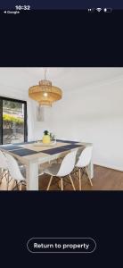 a dining room table with chairs and a chandelier at La Barca in Rye