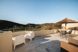 a balcony with white furniture and a table and chairs at Vida Pura Apartments in Odeceixe