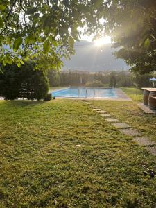 a swimming pool in a park with the sun setting at Gisshübelhof Apartments in Lana