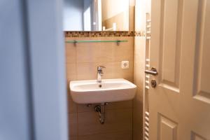 a bathroom with a sink next to a door at Schleiblick App 17 in Rabenkirchen-Faulück