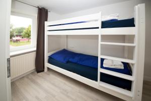 a bedroom with bunk beds with a window at Schleiblick App 19 in Rabenkirchen-Faulück