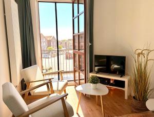 a living room with a television and a table and chairs at meerHAFEN in Orth