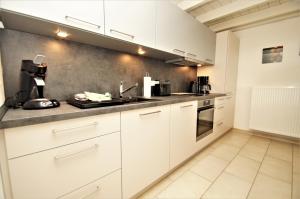 a kitchen with white cabinets and a sink at Nixe in Dahme