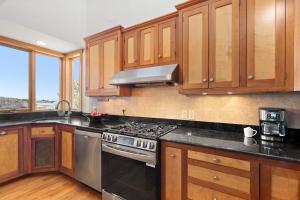 a kitchen with wooden cabinets and a stove top oven at Waterfront Escape Game Room Dog Friendly in Chatham
