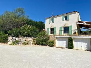 a large house with a stone wall and a garage at La Bastide in Saint-Saturnin-lès-Apt