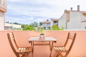a table and two chairs on a balcony with a plant at Ischera Apartments in Guspini