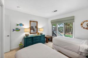 a bedroom with two beds and a mirror and a window at IC106: 106 Inlet Cove in Kiawah Island +45 photos