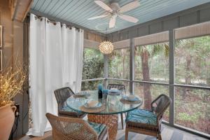 a dining room with a glass table and chairs at IC106: 106 Inlet Cove in Kiawah Island