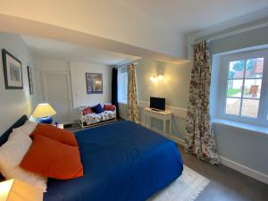 a bedroom with a blue bed and a window at Le clos du cèdre in Cellettes