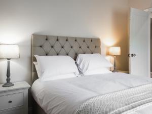 a bedroom with a white bed with two white pillows at Beachcmbers Cottage - Uk51638 in Carsethorn