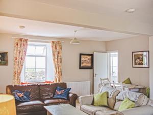 a living room with two couches and a table at Beachcmbers Cottage - Uk51638 in Carsethorn