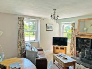 a living room with a couch and a tv at Staffield Cottage - Uk35714 in Kirkoswald
