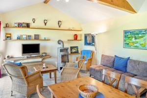 a living room with a couch and a tv at Bungalow am Haussee in Himmelpfort